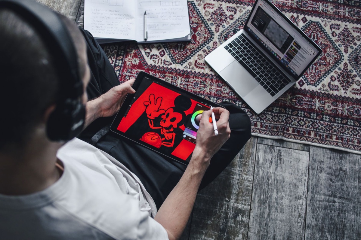 Deutscher Youtuber mit Laptop und Tablet