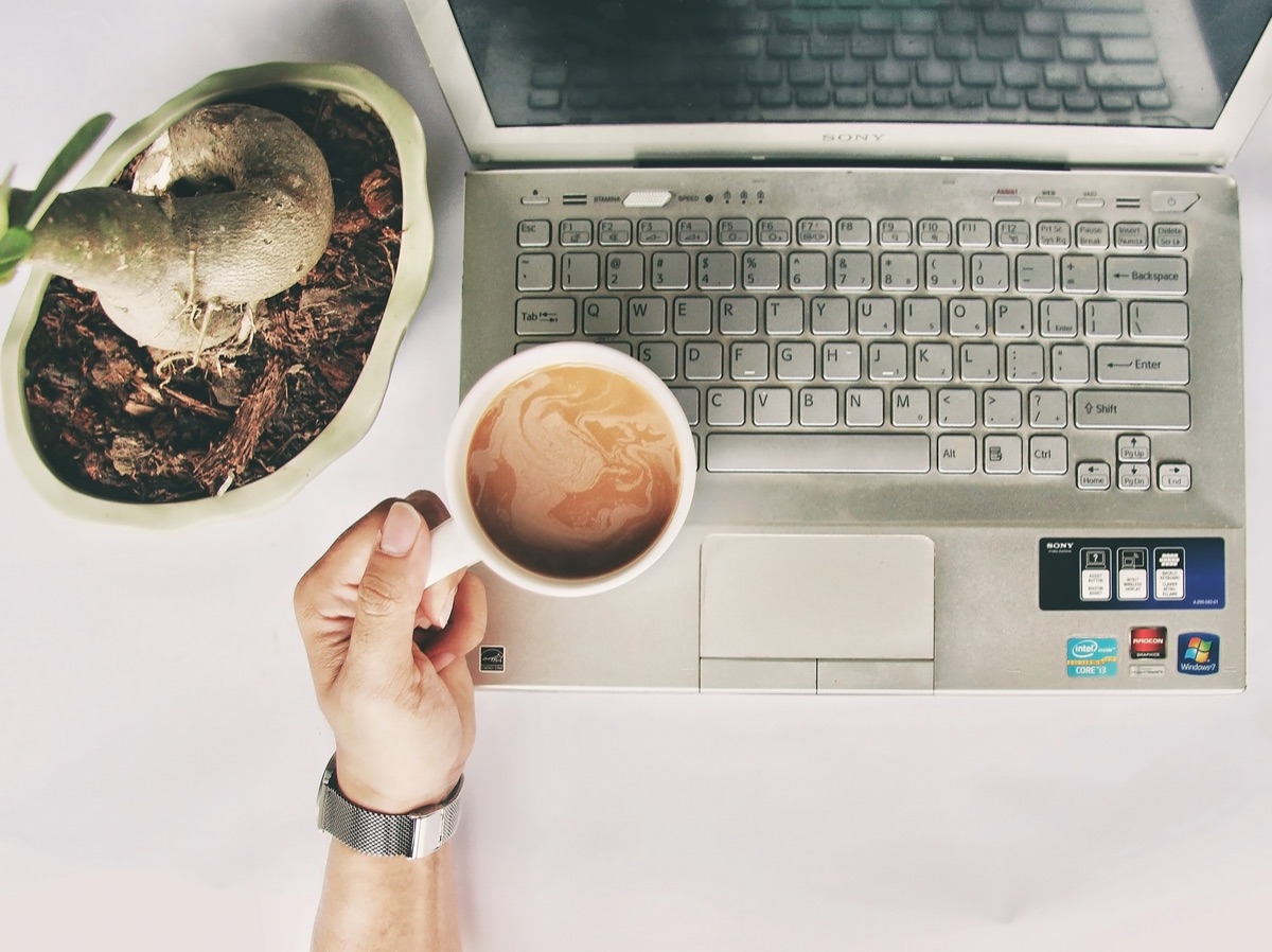 Deutscher YouTuber mit Laptop und Kaffeetasse